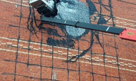 Мурал с портретом известного священника и астронома рисуют на стене дома в Кашире-2